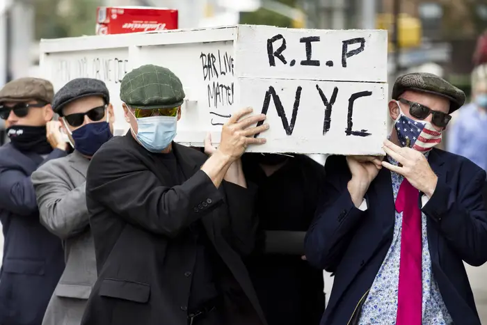 People carrying a coffin, intended to represent the death of the restaurant industry, participate in a protest at Governor Andrew Cuomo's New York office.
